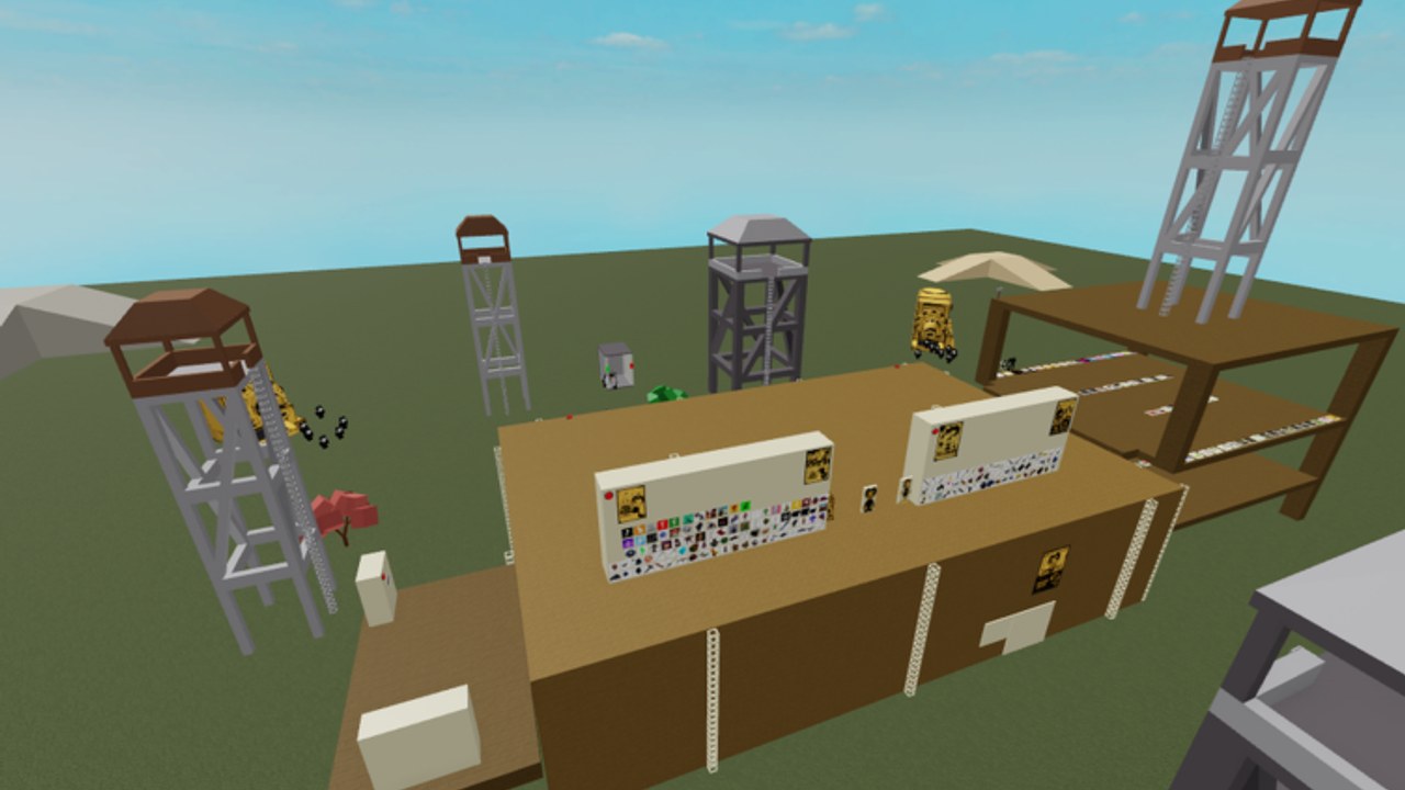 Aerial view of the Bendy scripts compound showing two white gear walls on a brown studio block and surrounding watchtowers.